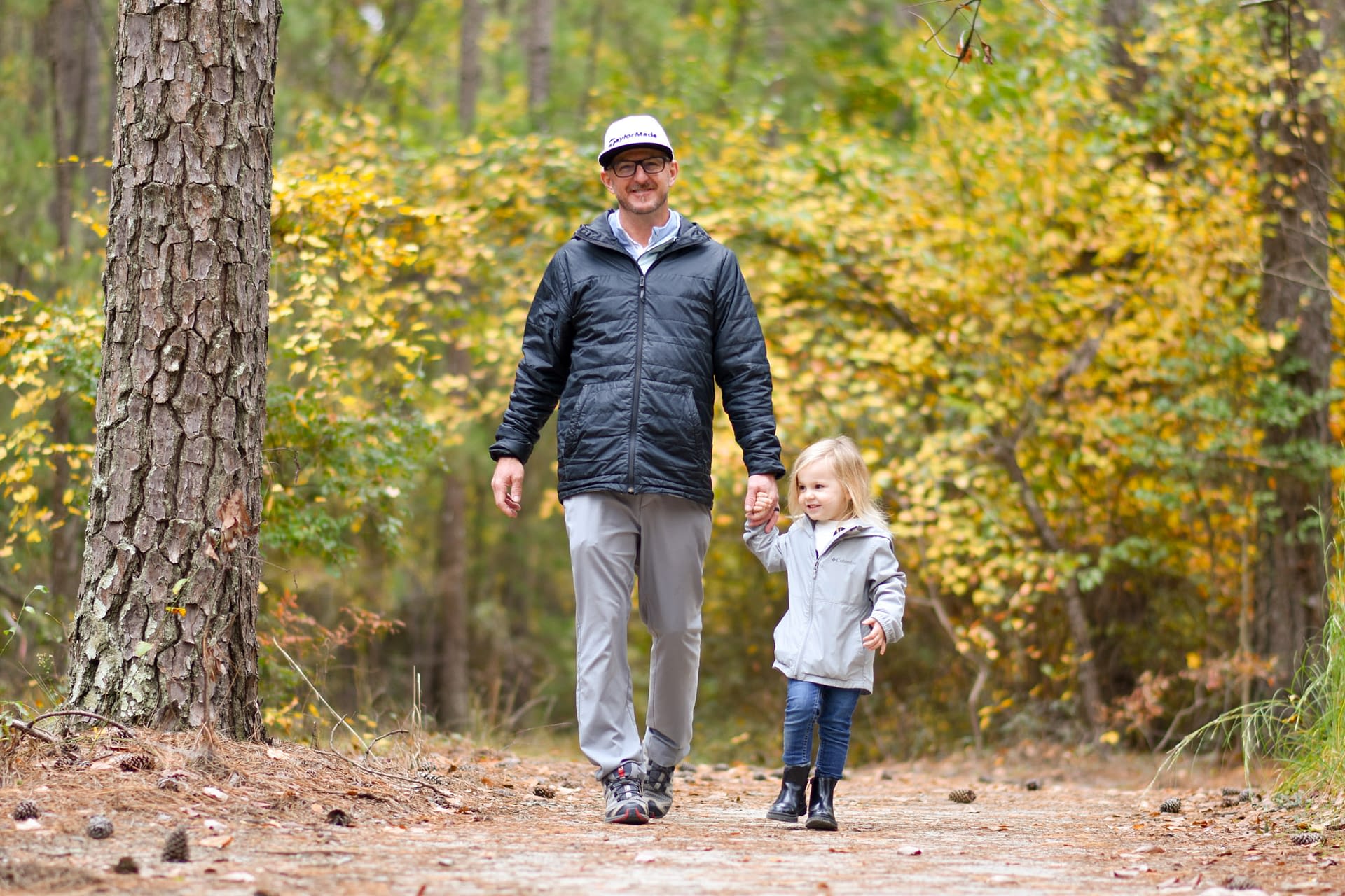 Father and daughter on a walk in the woods on a nice day