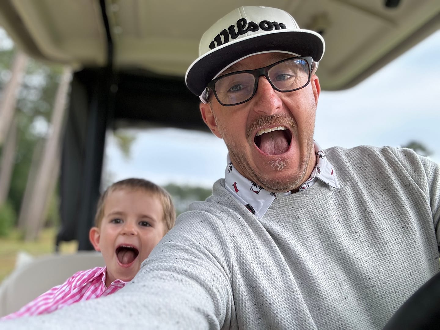 Father and Son during a round of golf in the golf cart