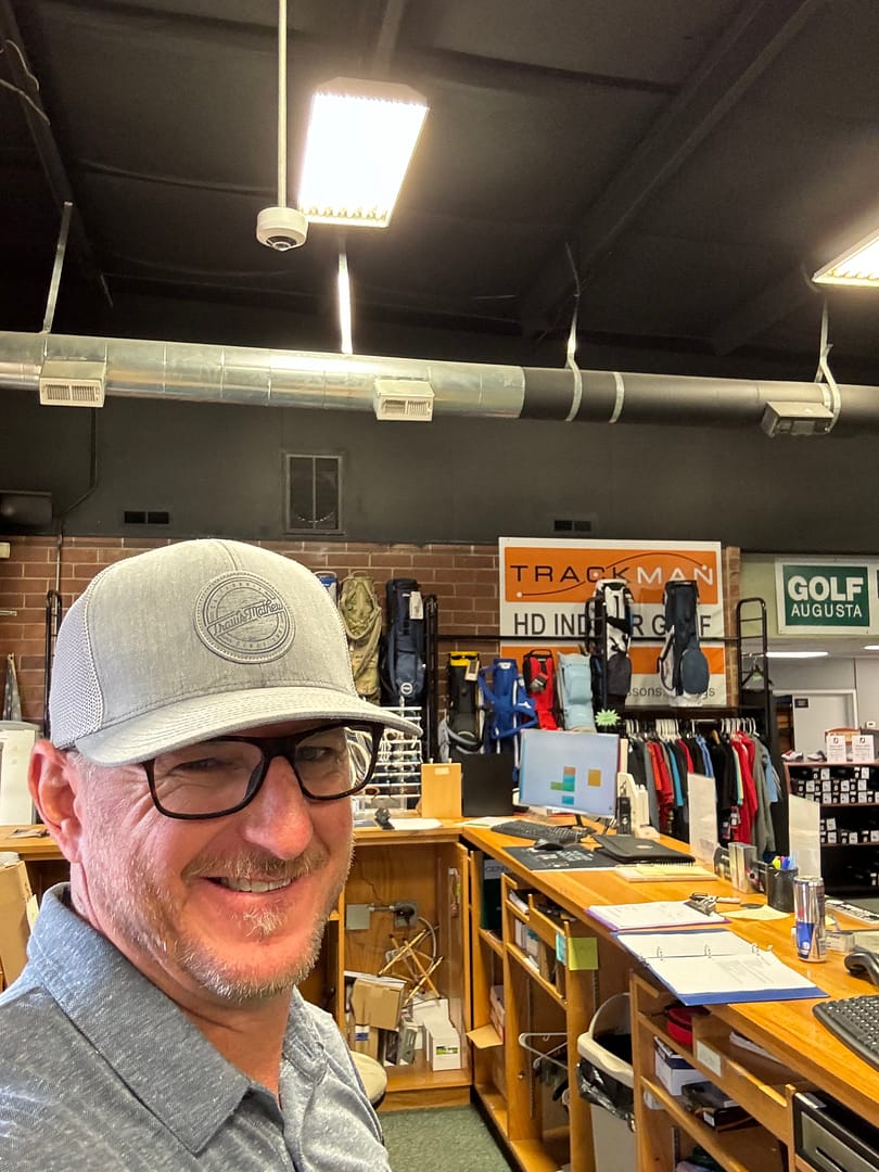 Father at work in a golf shop helping costumers find whats best for them