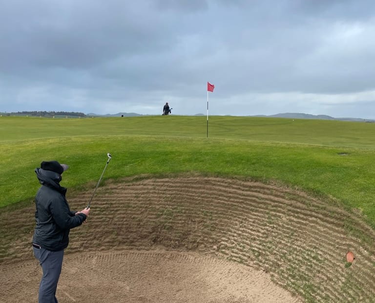 Golfer taking in options to use during bunker shot. Showing resilience